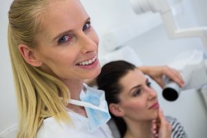 Dentist taking a female patients tooth x-ray in clinic