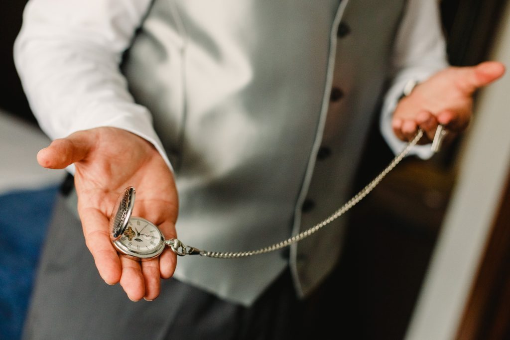 Old pocket watch in the hands of a man